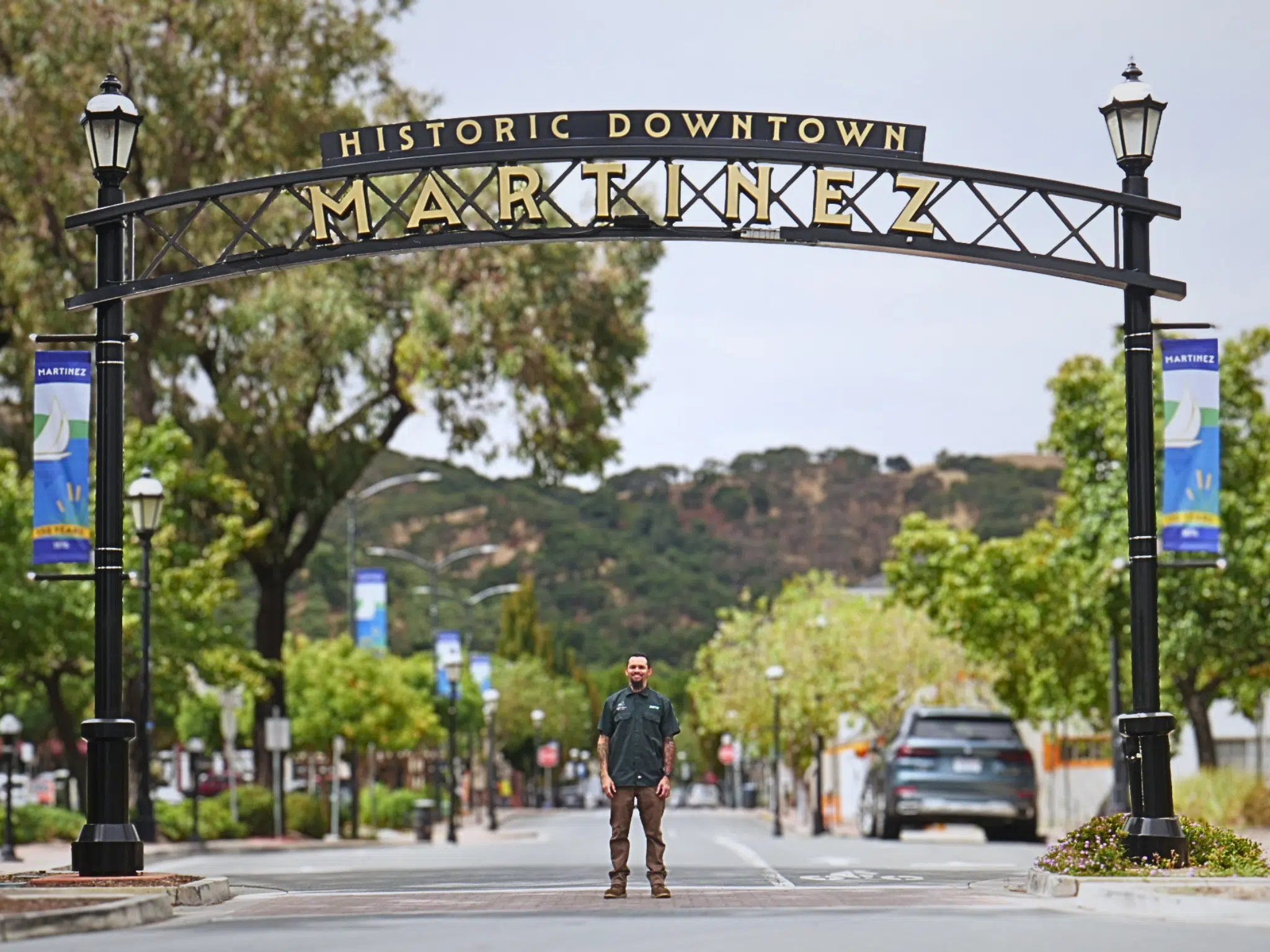 Dustin Cantu of Generational Garage Doors standing under the City of Martinez sign in downtown Martinez CA