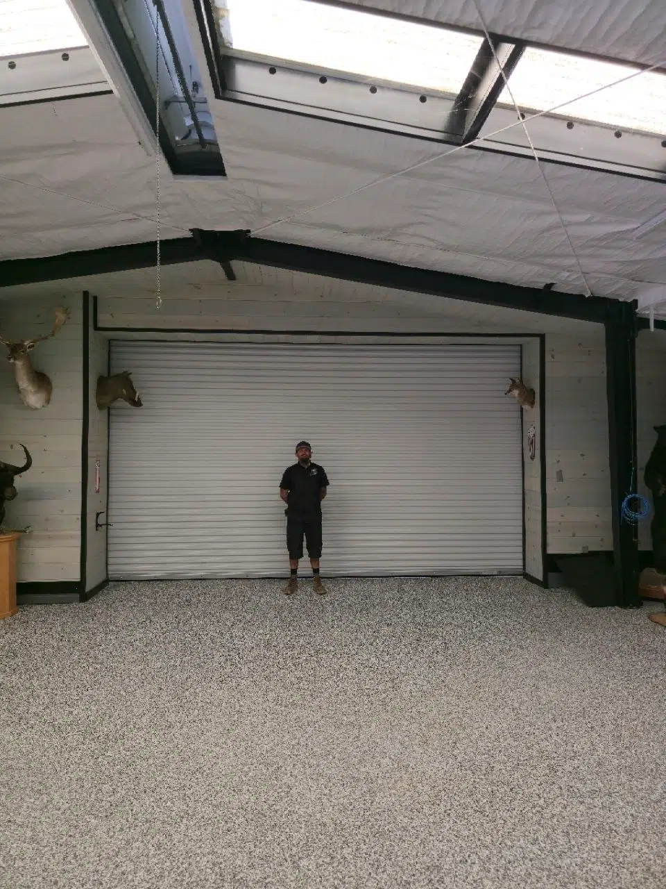 Dustin Cantu in front of a 17 by 9 foot 6 rolling sheet garage door installation